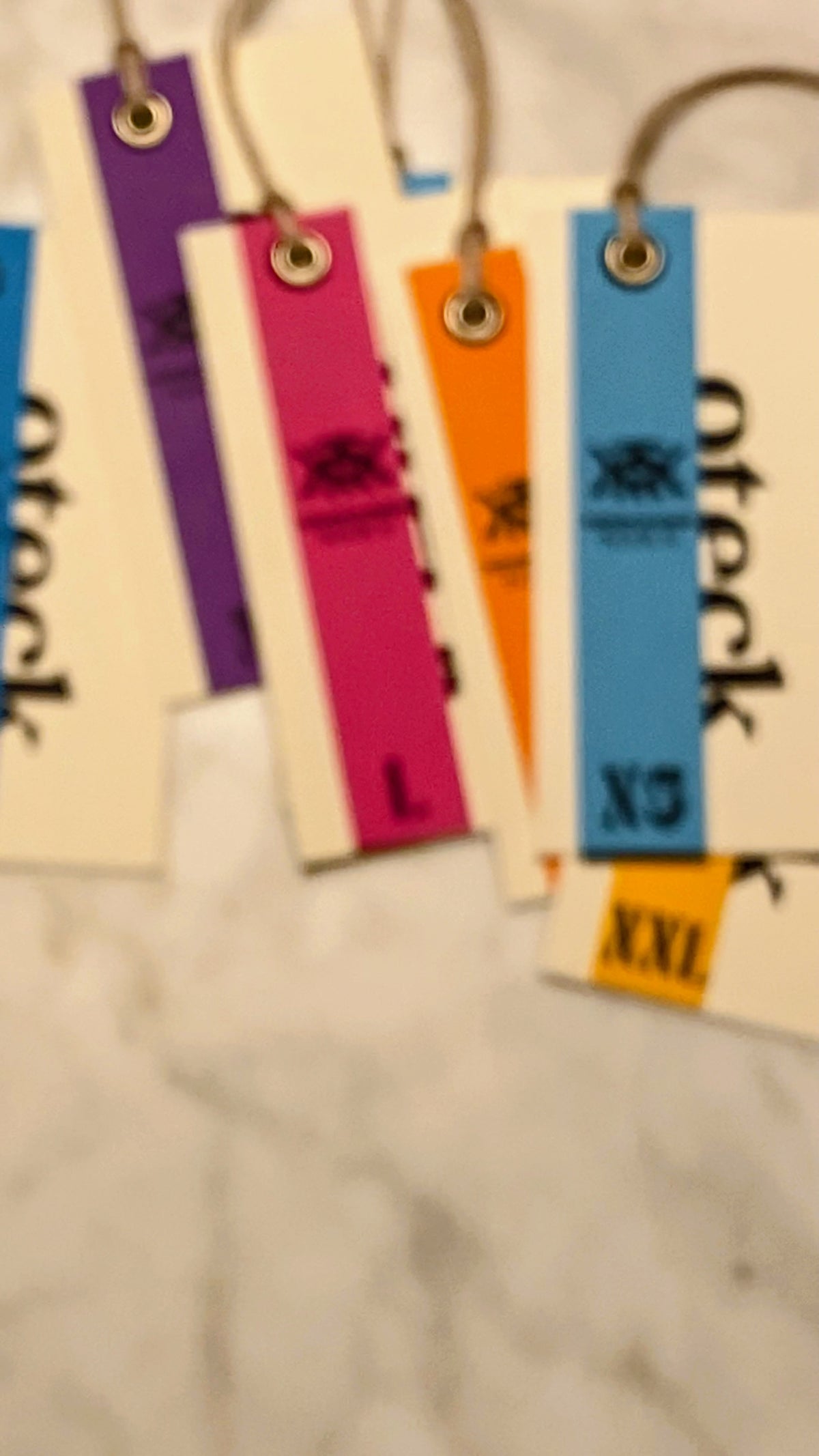 Hangtags skurna i kartong. Fästa med säkerhetsnål.